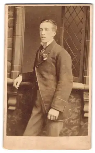 Fotografie Stuart Brothers, Knightsbridge, 47 Brompton Road, Portrait junger Mann im feinen Anzug mit Blume