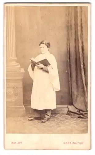 Fotografie H. Bailly, Kensington, 4 Newland Terrace, Portrait kleiner Junge als Küster im Gewand mit Gesangsbuch