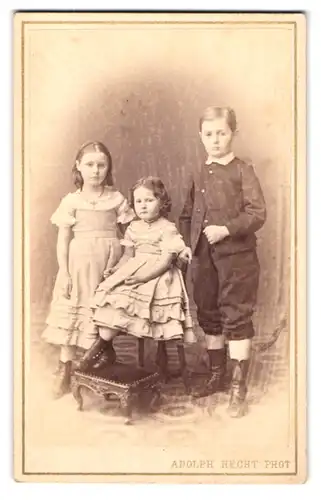 Fotografie Adolph Hecht, Magdeburg, Stephansbrücke 15, Zwei junge Mädchen in Kleidern mit grossem Bruder