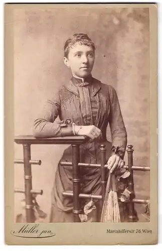 Fotografie M. Müller Junior, Wien, Mariahilferstrasse 76, junge Dame mit Fächer in Hand auf Zaun lehnend