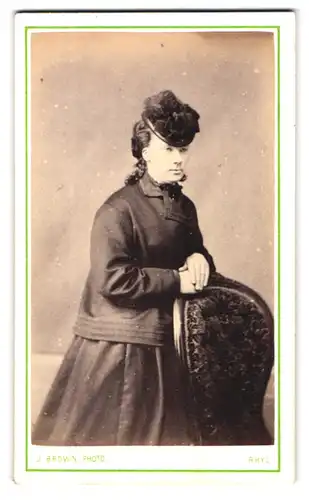 Fotografie J. Brown, Rhyl, 3 Kinmel Street, Portrait modisch gekleidete Dame an Stuhl gelehnt