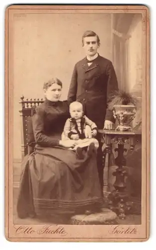 Fotografie Otto Faehte, Görlitz, Grüner Graben 29, Portrait bürgerliches Paar mit einem Kleidnkind