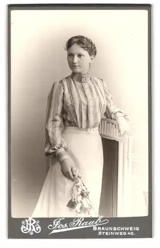 Fotografie Joseph Raab, Braunschweig, Steinweg 42, junge Dame mit Blumen in Hand auf Zaun lehnend