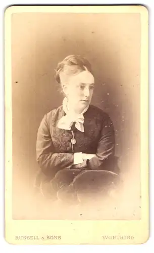 Fotografie Russel & Sons, Worthing, Bath Place, Portrait Dame mit weisser Schleife um Hals runterschauend