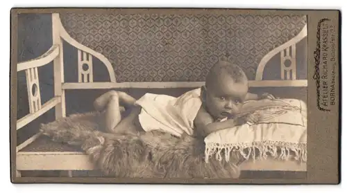 Fotografie Richard Krasselt, Borna, Bahnhofstrasse 32, Portrait niedliches Baby im weissen Hemd auf Bank liegend
