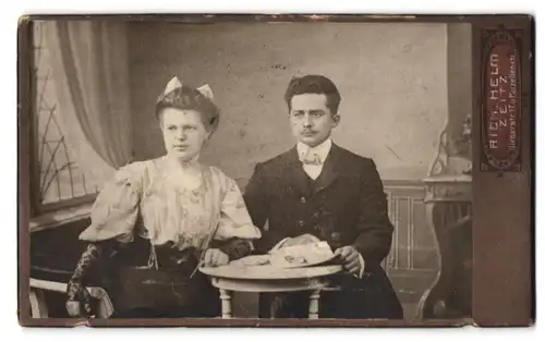 Fotografie Rich. Helm, Zeitz, Weberstrasse 17, Portrait bürgerliches Paar mit Heft am Tisch sitzend