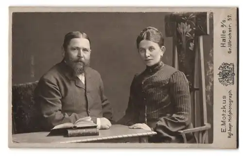 Fotografie E. Motzkus, Halle a / S., Gr. Ulrichstrasse 57, Portrait bürgerliches Paar mit Büchern am Tisch sitzend