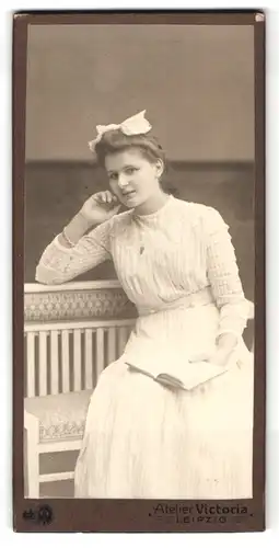 Fotografie Atelier Victoria, Leipzig, Rossplatz 6, Portrait bezauberndes Fräulein mit Haarschleife und Buch in der Hand