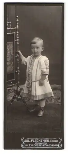 Fotografie Jul. Flechtner, Unna, Portrait blondes kleines Mädchen mit Schnürstiefel und besticktem Kleidchen