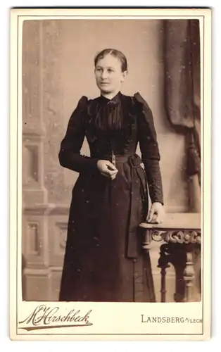Fotografie M. Hirschbeck, Landsberg a. Lech, Portrait hübsche Dame im gerüschten Kleid und Brosche am Kragen