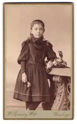 Fotografie W. Breuning, Hamburg, Berg-Strasse 26, Portrait niedliches Mädchen mit Blume in der Hand