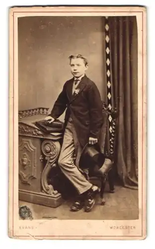 Fotografie E. Evans, Worcester, Portrait Knabe in modischer Kleidung an Pult gelehnt