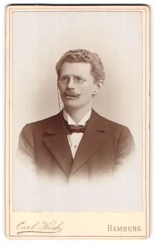 Fotografie Carl Koch, Hamburg, Neuerwall 30, Portrait Mann im Anzug mit Moustache und Locken, Zwicker Brille