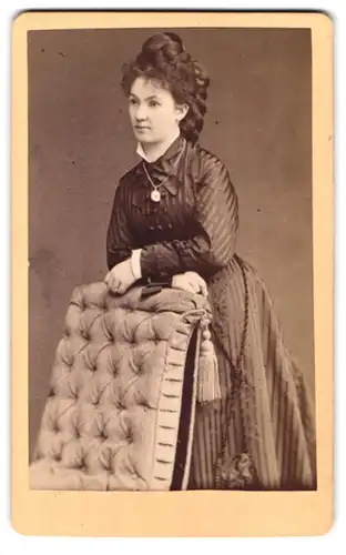 Fotografie Carl Hempel, Pössneck, Portrait junge Frau im gestreiften Kleid mit Locken und Zopf