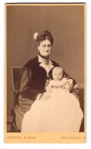 Fotografie Gottheil & Sohn, Königsberg i. P., Münzstrasse 6, Portrait Mutter im Kleid mit Zopf und Baby auf dem Schoss