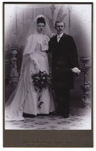 Fotografie Willibald Hartmann, Gross Schönau i/S., Portrait elegante Brautleute in einer Studiokulisse