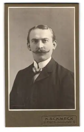 Fotografie H. Schmeck, Siegen, Bahnhofstr. 12, Portrait Herr im Jacket mit Fliege und modisch frisiertem Schnauzbart