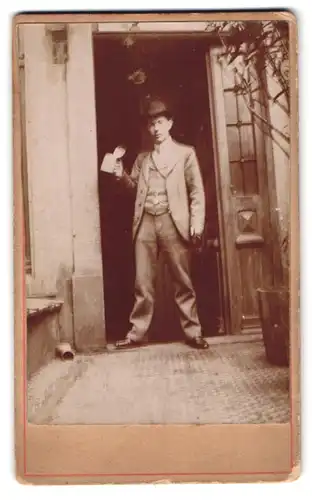 Fotografie junger Mann mit Hut und Bierkrug in einer Tür stehend, Schnappschuss