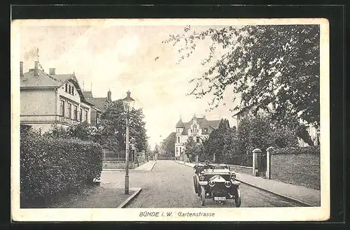 AK Bünde i. W., Blick in die Gartenstrasse mit Häusern, Automobil und Laterne