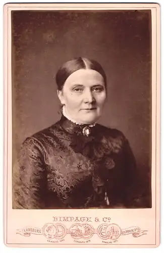 Fotografie Bimpage & Co., Lüneburg, Portrait Dame in schöner Bluse mit Brosche