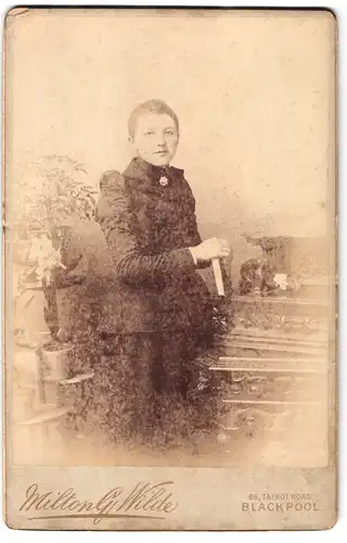 Fotografie Milton G. Wilde, Blackpool, 86 Talbot Road, Portrait junge Dame in modischer Kleidung mit Buch