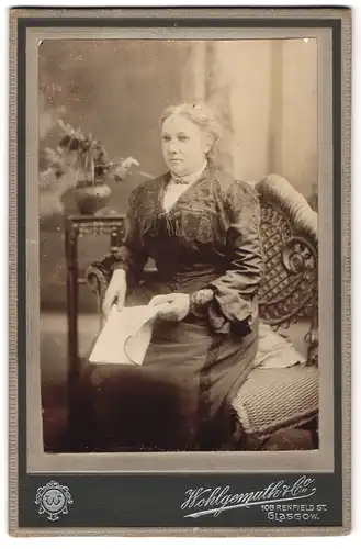 Fotografie Wohlgemuth & Co., Glasgow, 108 Renfield St., Portrait bürgerliche Dame mit Heft auf Stuhl sitzend