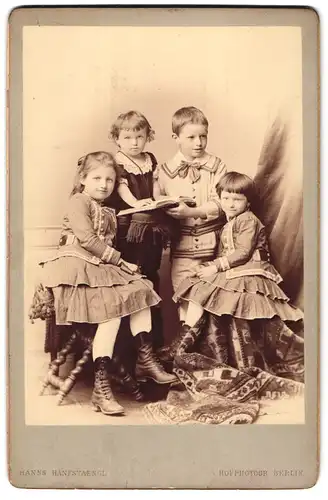 Fotografie Hanns Hanfstaengl, Berlin, Unter den Linden 19, Portrait drei Mädchen und Junge in hübscher Kleidung mit Buch