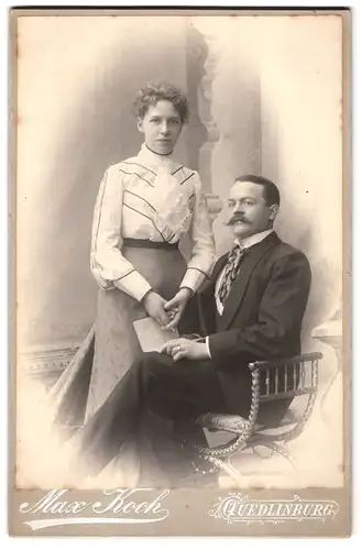 Fotografie Max Koch, Quedlinburg, Portrait bürgerliches Paar in modischer Kleidung mit Buch