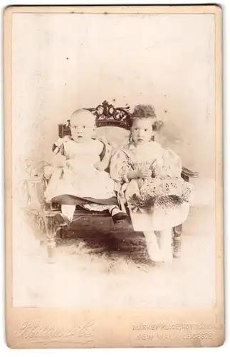 Fotografie Phillips & Co, Nottingham Market Place, Mädchen mit gelockten Haaren mit Kleinkind in Kleidchen
