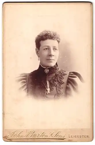 Fotografie John Burton & Son, Leicester, Dame mit kurzen gelockten Haaren trägt mit Stickereien geschmücktes Kleid