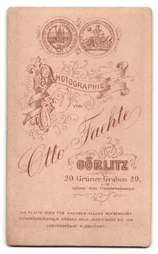 Fotografie Otto Faehte, Görlitz, Grüner Graben 29, Portrait elegant gekleidetes Paar am Holzzaun stehend