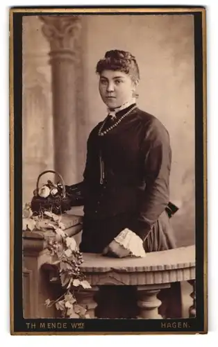 Fotografie Th. Mende, Hagen i. W., Elberfelderstr. 82, Portrait bildschöne junge Frau mit Perlenhalskette und Blumenkorb