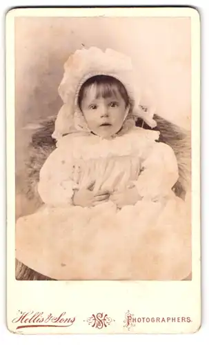 Fotografie Hellis & Sons, London, 30 Clapham Road, Portrait süsses Kleinkind im Kleidchen und Häubchen