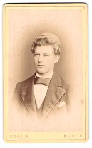 Fotografie R. Müller, Dresden, Marienstr. 26, Portrait junger Mann mit blondem Haar und Fliege im Jackett