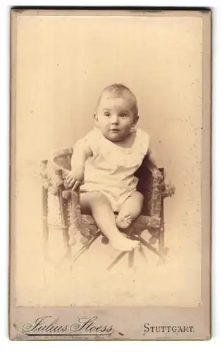 Fotografie Julius Stoess, Stuttgart, Eberhardstr. 47, Portrait süsses Kleinkind im weissen Kleidchen auf dem Stuhl sitzend