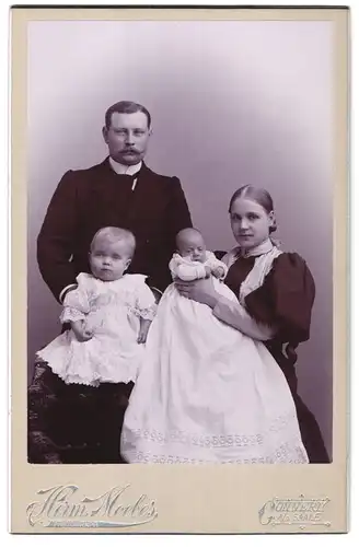 Fotografie Herm. Moebes, Cönnern /Saale, Portrait junge Eltern mit Babys in Taufkleidern