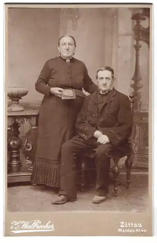 Fotografie H. Walbrecker, Zittau, Mandau Allee, Portrait älteres Paar in schwarzer Kleidung mit Buch
