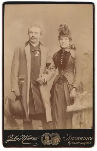 Fotografie Gebr. Martin, Augsburg, Bahnhofstr., Herr mit Melone und Dame mit Korsett mit verschränkten Armen