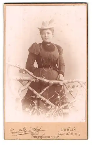 Fotografie Emil Rosenthal, Berlin, Königstr. 31, Portrait junge Frau im dunklen Kleid trägt einen Hut mit Federschmuck