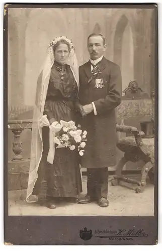 Fotografie K. Müller, Memmingen, vor dem Ulmer Tor, Bräutigam mit Ordenspange nebst Hochzeitsbraut