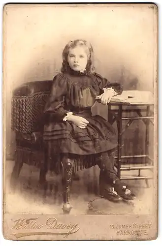 Fotografie Walter Davey, Harrogate, 10, James Street, Portrait hübsch gekleidetes Mädchen mit Buch am Tisch sitzend