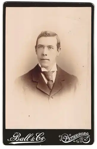 Fotografie Ball & Co., Peterboro, Portrait junger Mann im Anzug mit Krawatte