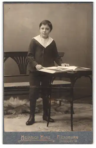 Fotografie Heinrich Hinz, Flensburg, Toosbüystrasse 15, Portrait halbwüchsiger Knabe im Matrosenanzug mit einem Buch
