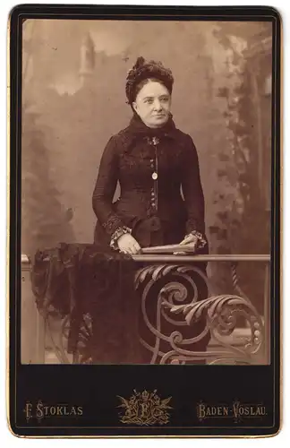 Fotografie F. Stoklas, Baden-Vöslau, Portrait bürgerliche Dame mit Fächer an Geländer gelehnt
