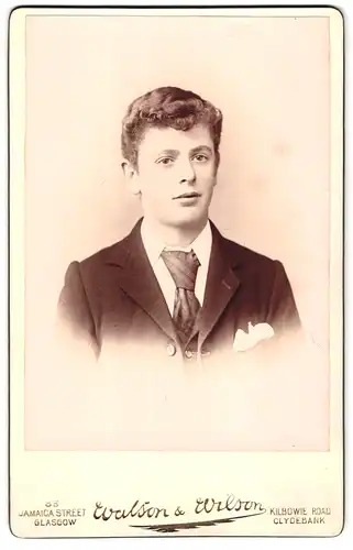 Fotografie Walson & Wilson, Glasgow, 83 Jamaica Street, Portrait hübscher junger Mann mit welligem Haar im Jackett
