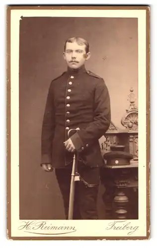 Fotografie H. Reimann, Freiberg, Weingasse 9, Portrait Soldat mit Oberlippenbart, Degen mit Portepee