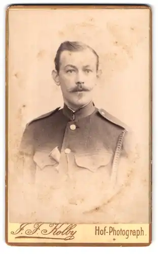 Fotografie J. F. Kolby, Plauen i. Vogtl., Portrait Eisenbahner in Uniform mit eingesteckten Signalhorn