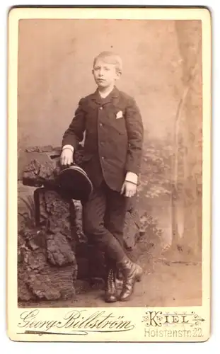 Fotografie Georg Billström, Kiel, Holstenstr. 22, Portrait frecher blonder Bube mit Mütze im Anzug