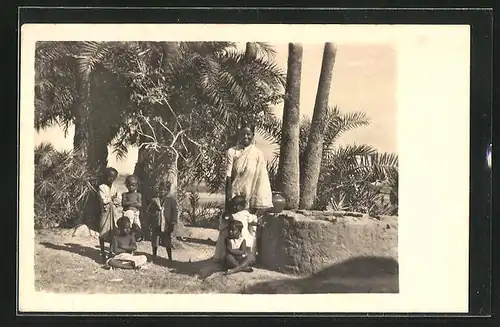 AK Indien, Frau in Tracht an einem Brunnen