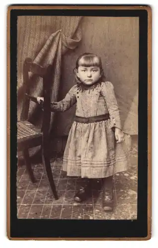 Fotografie unbekannter Fotograf und Ort, Portrait niedliches kleines Mädchen im gestreiften Kleidchen